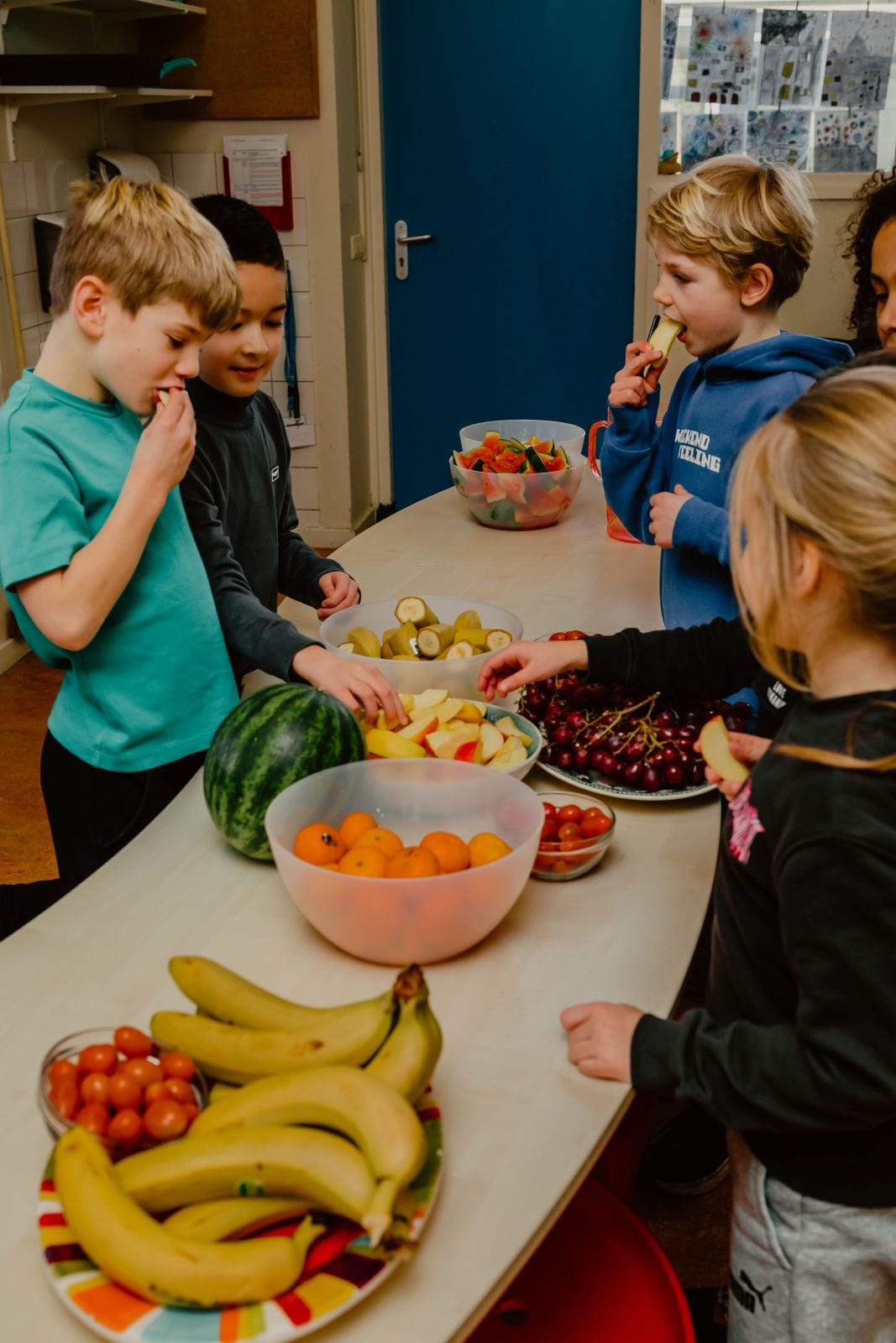 Leerlingen eten schoolfruit aan tafel