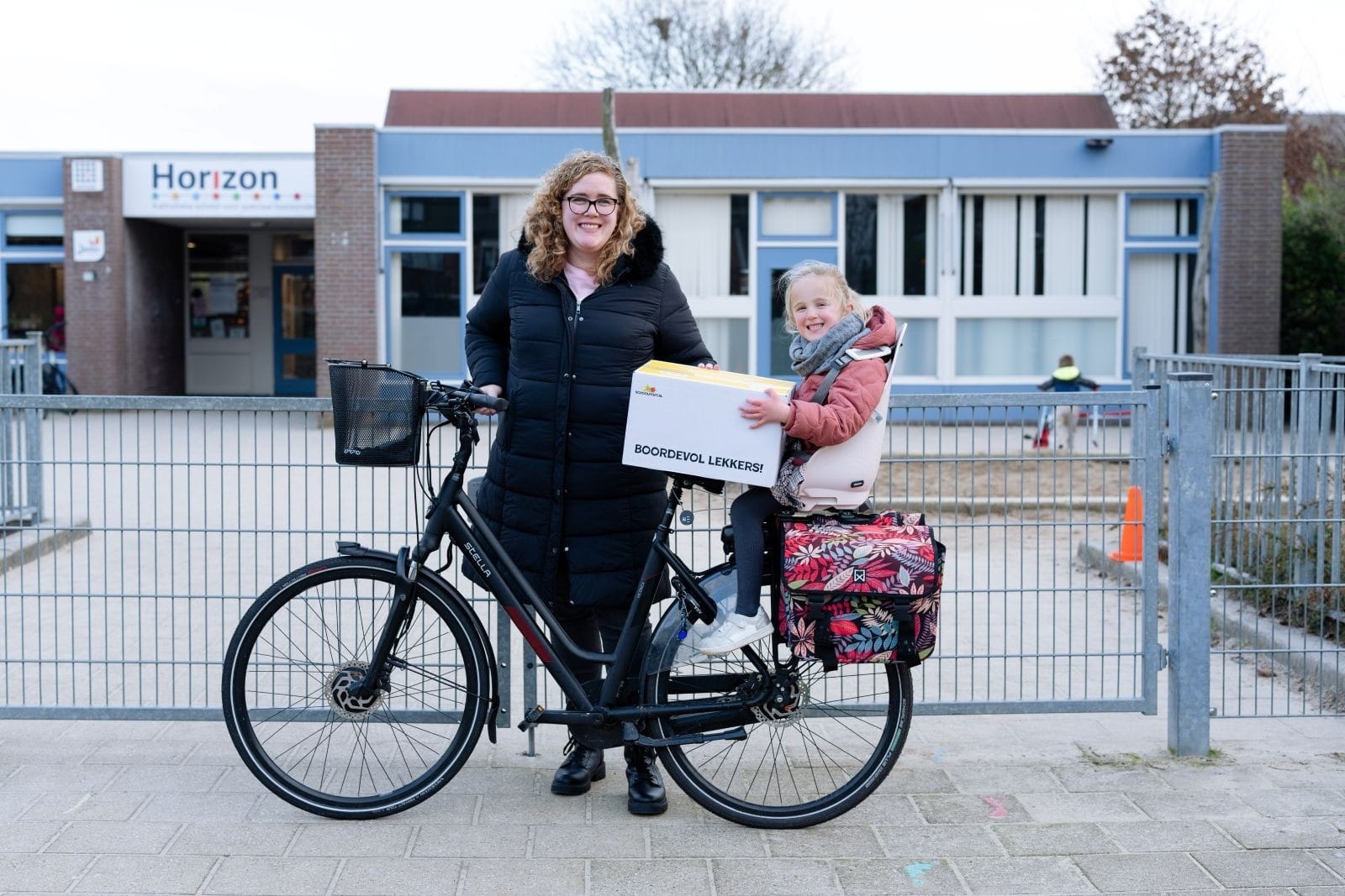 Moeder en kind op fiets met pakket