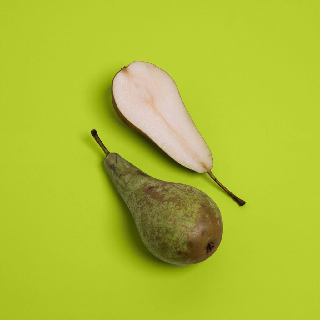 Hele en gehalveerde peer op groene achtergrond