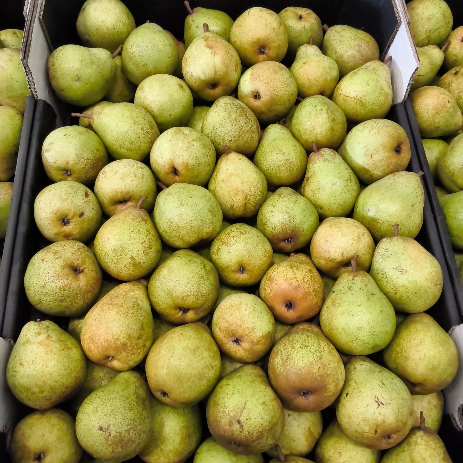 Groene peren in zwarte winkelkratten