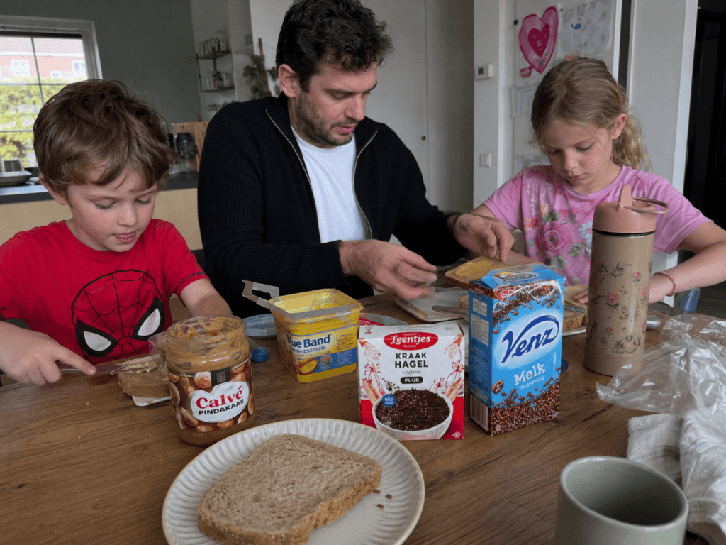 Vader en kinderen maken brood aan tafel