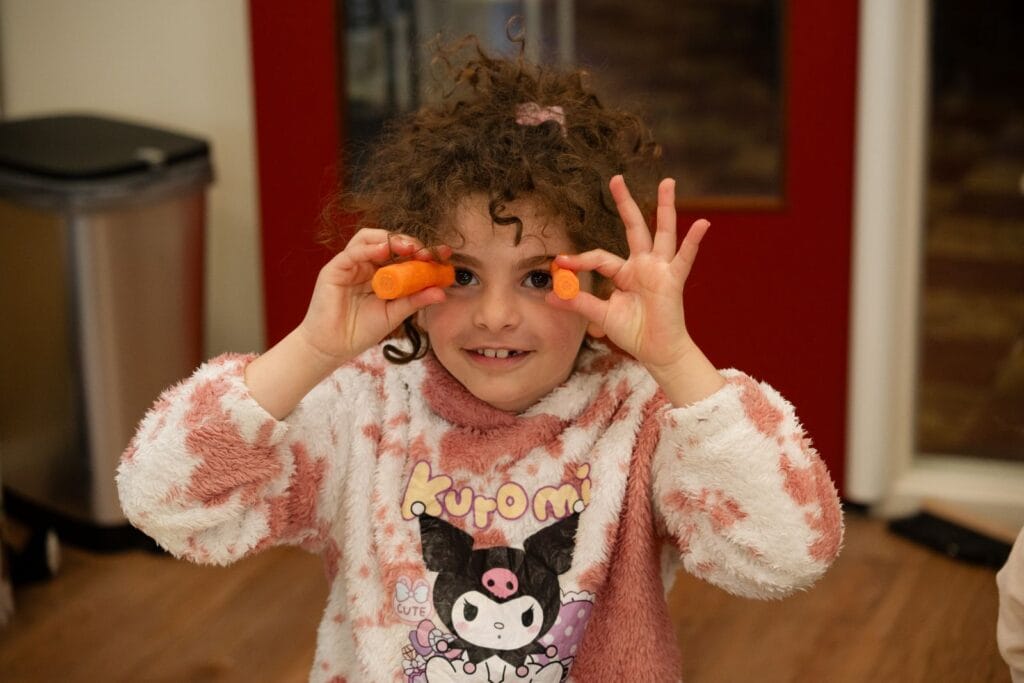 Meisje houdt wortels voor haar ogen