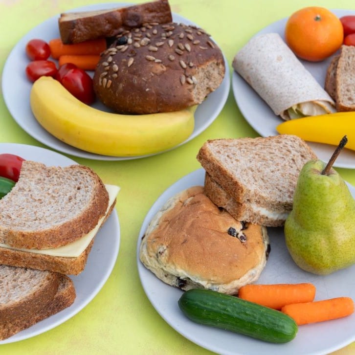 Borden met broodjes, fruit en rauwkost