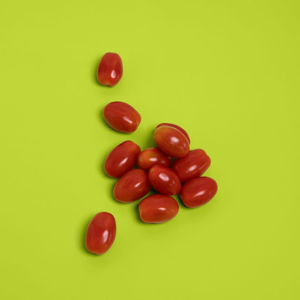 Rode cherrytomaten op felgroene achtergrond