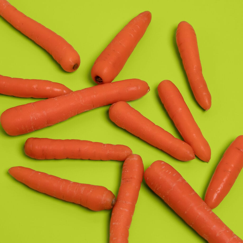 Oranje wortels op felgroene achtergrond